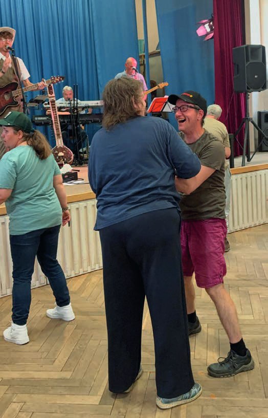 Die Band ASB auf der Bühne: eine Sängerin an Trommeln und ein Sänger mit Cowboyhut und Gitarre vor blauen Vorhängen.